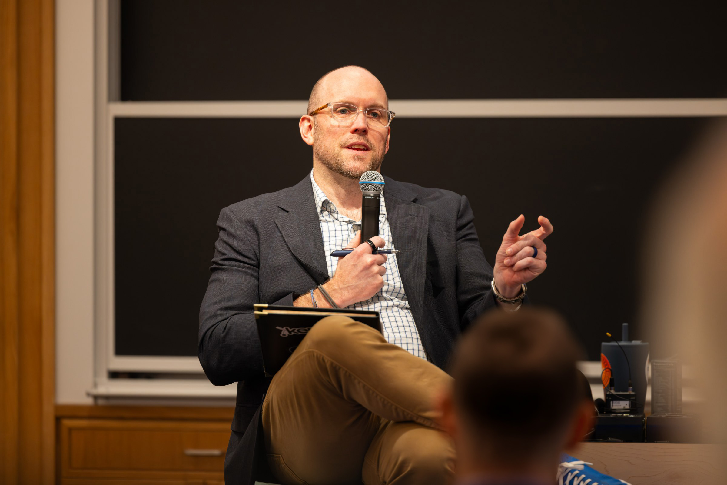 Adam Kerpelman speaking on a panel, microphone in hand
